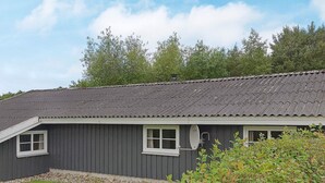 A single-story building with a dark grey exterior, a sloped roof, and a satellite dish mounted on the side. - 6 Person Holiday Home in Sydals (Sydals)