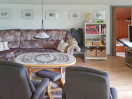 A living room with a patterned sofa, a round coffee table, and a bookshelf.