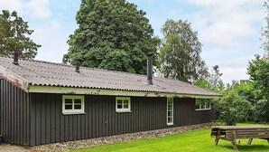 A single-story building with a corrugated metal roof, two windows with white frames, and a chimney. - 6 Person Holiday Home in Sydals (Sydals)