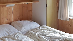 A single bed with white bedding in a room with wooden paneling and a window with curtains. - 6 Person Holiday Home in Sydals (Sydals)