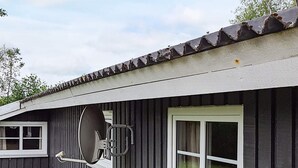 A house with a satellite dish, a window with curtains, and a tiled roof. - 6 Person Holiday Home in Sydals (Sydals)