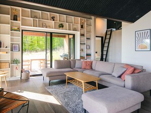 A modern living room with a sectional sofa, a coffee table, and built-in shelving. - 5 Star Holiday Home in Sjolund (Sjølund)