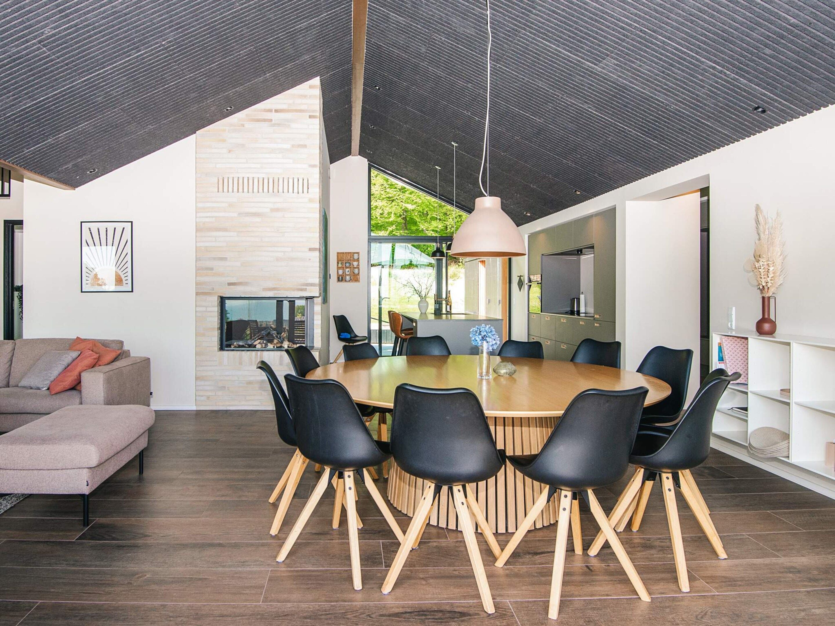 Een modern interieur met een eethoek, een bank en een open haard.