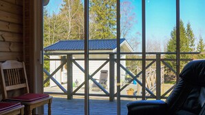 Un intérieur en bois avec une grande fenêtre donnant sur une terrasse.