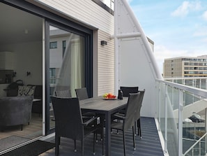 A balcony with a table and chairs, a sliding glass door, and a view of the cityscape. - 5 Star Holiday Home in Wendtorf (Wendtorf)
