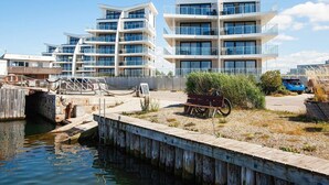 A waterfront property with modern buildings, a dock, and a bicycle.