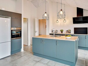 A modern kitchen with a central island, built-in appliances, and pendant lighting. - 5 Star Holiday Home in Lokken (Lokken)