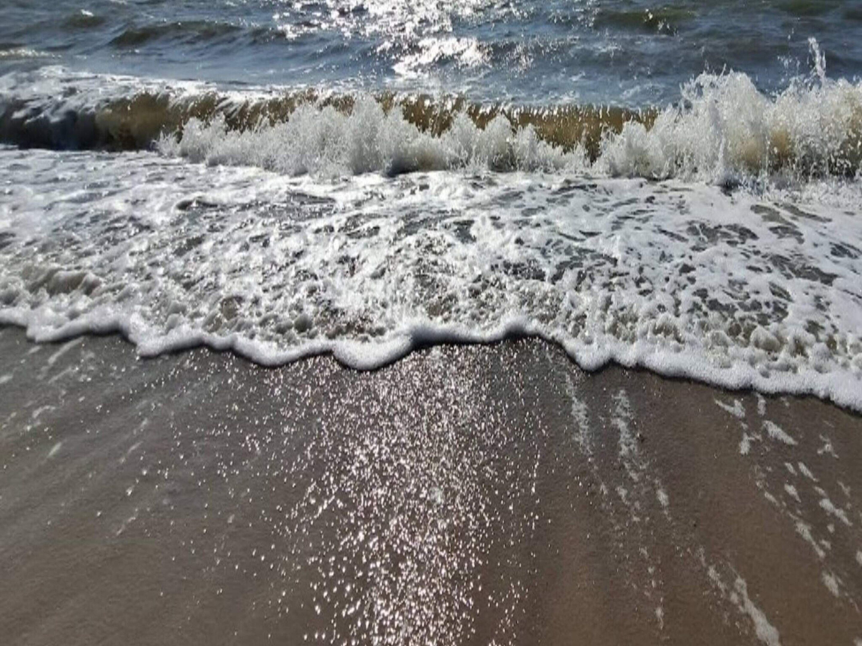 A beach with waves crashing onto the shore.