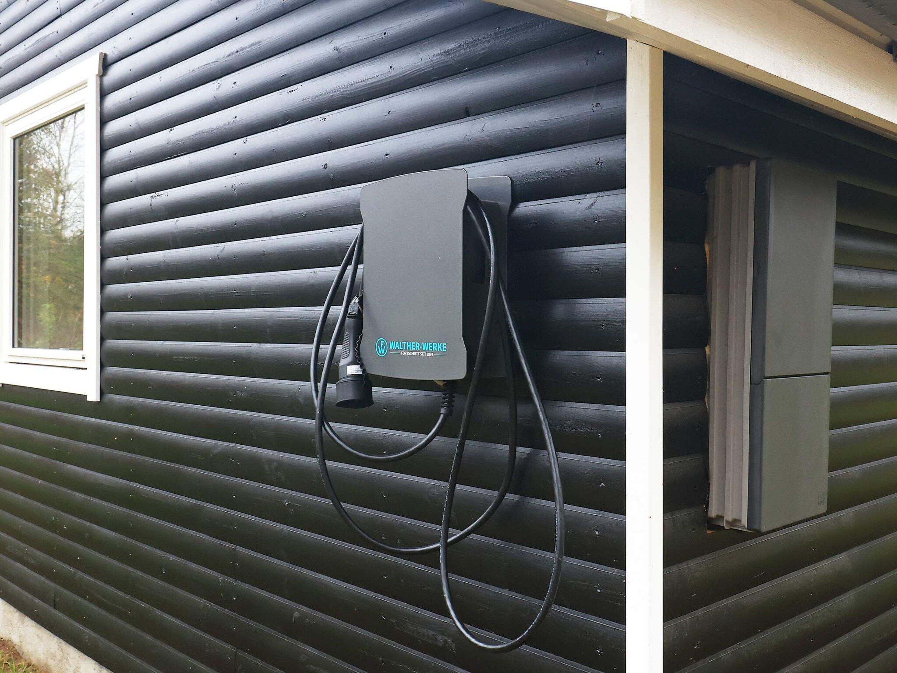 A black exterior wall with a window and a wall-mounted electrical box.