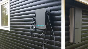 A black exterior wall with a window and a wall-mounted electrical box.