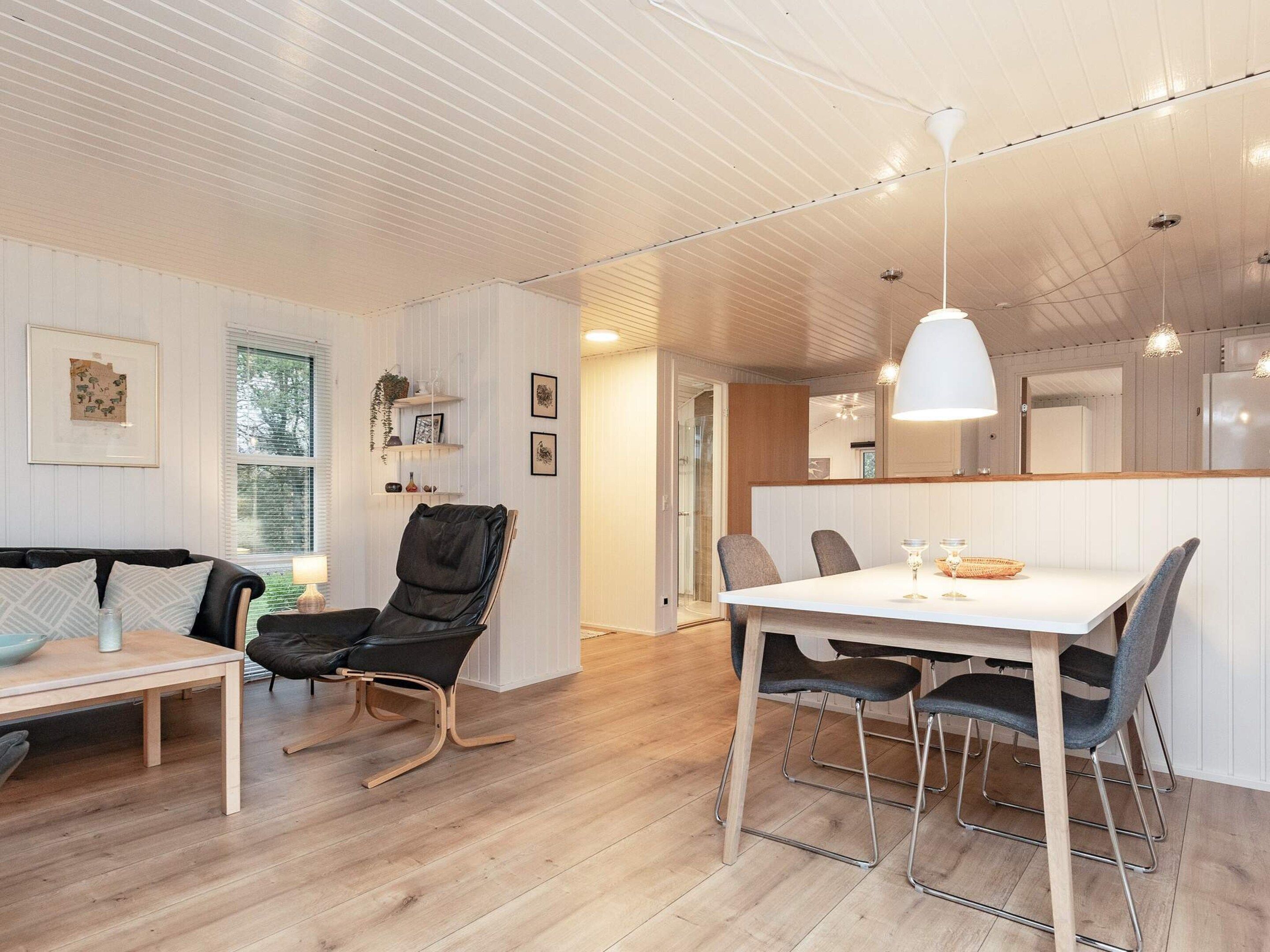 A modern interior with a dining area, a sofa, and a chair.