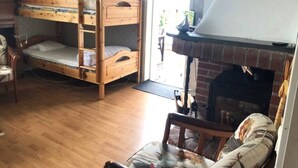 Um quarto com uma cama beliche, lareira e uma cadeira.