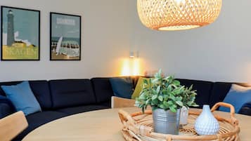 A round table with a woven placemat, a potted plant, and a decorative vase.