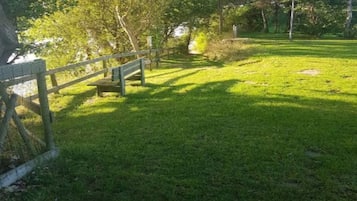A grassy park area with a wooden bench and a lamp post.