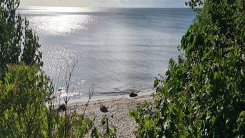 A beach with a clear view of the ocean and a sandy shore.