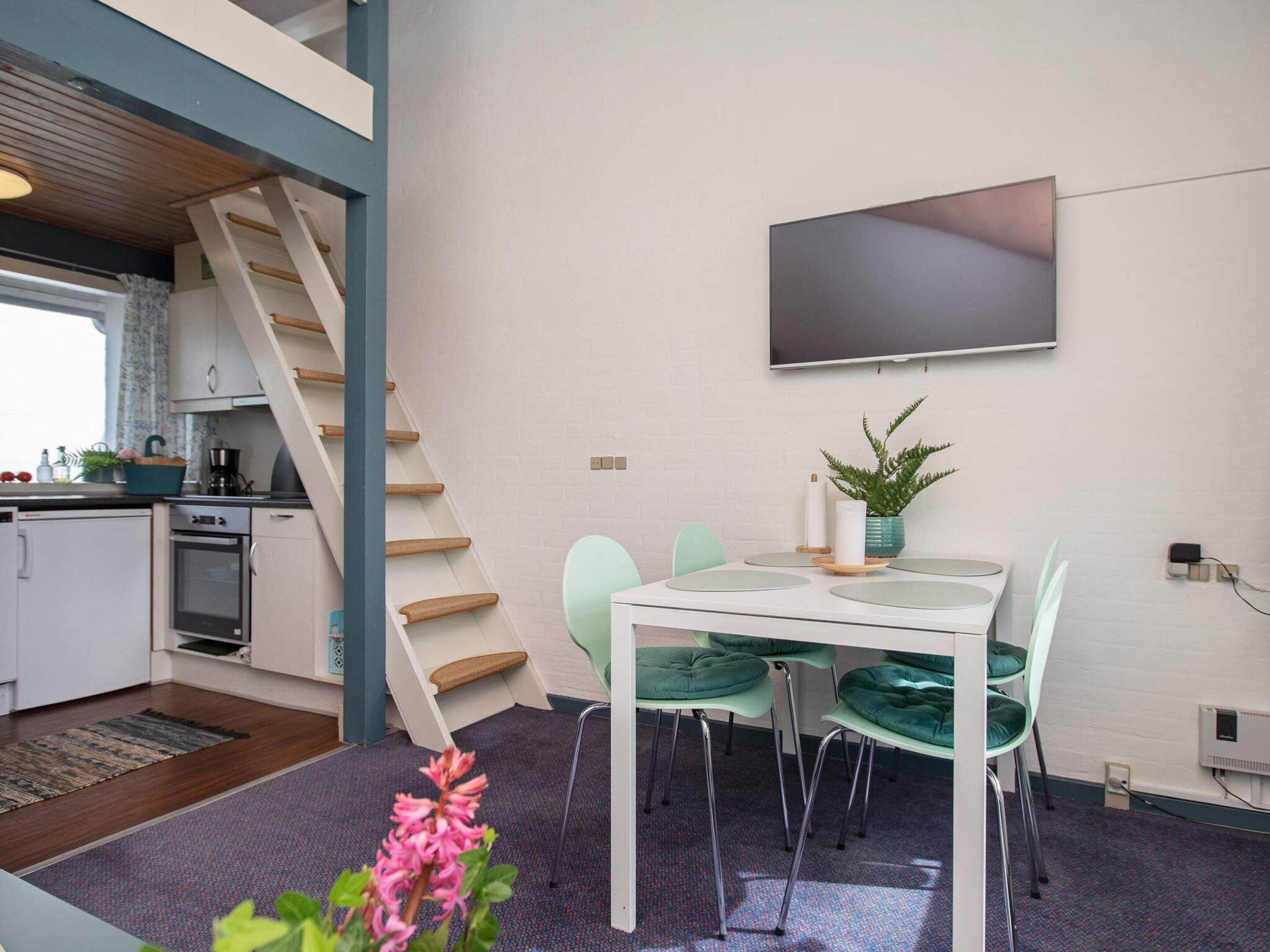 A compact kitchen with a built-in oven and a small refrigerator.
