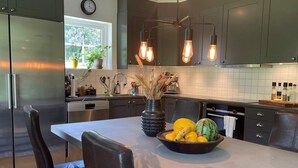 A modern kitchen with stainless steel appliances, a central island with a fruit bowl, and pendant lighting. - 5 Star Holiday Home in Klovedal (Klovedal)