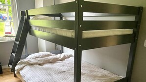 A bunk bed with a ladder, a window with a view of the outside, and a power outlet on the wall. - 5 Star Holiday Home in Klovedal (Klovedal)