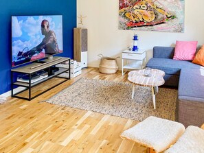 A living room with a television, a blue sofa, a coffee table, and a rug. - 5 Star Holiday Home in Klovedal (Klovedal)