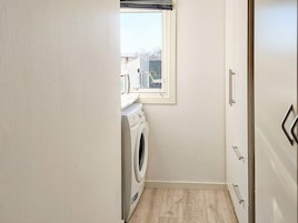 Un cuarto de lavandería con lavadora, secadora y ventana.