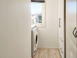 Un cuarto de lavandería con lavadora, secadora y ventana.