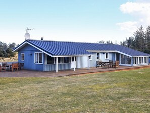 A blue building with a sloped roof and a covered patio area. - 4 Star Holiday Home in Lokken (Lokken)