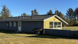 Un bâtiment d’un seul étage, doté d’un toit à pignon, d’une antenne parabolique et d’un petit porche.