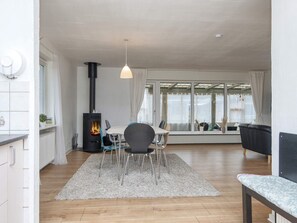 Una sala de estar moderna con chimenea, comedor y zona de estar con vistas.