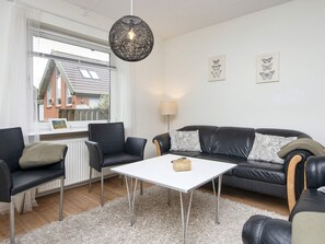 A modern living room with a sofa set, a white coffee table, and a hanging light fixture. - 8 Person Holiday Home in Hvide Sande (Hvide Sande)