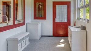 A compact kitchen with a white refrigerator, a sink, and a window with a curtain. - 4 Person Holiday Home in Vaeggerlose (Vaeggerlose)