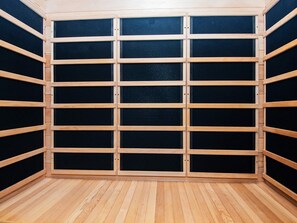 Een kamer met een raster van houten panelen en een zwart gaaszeef.
