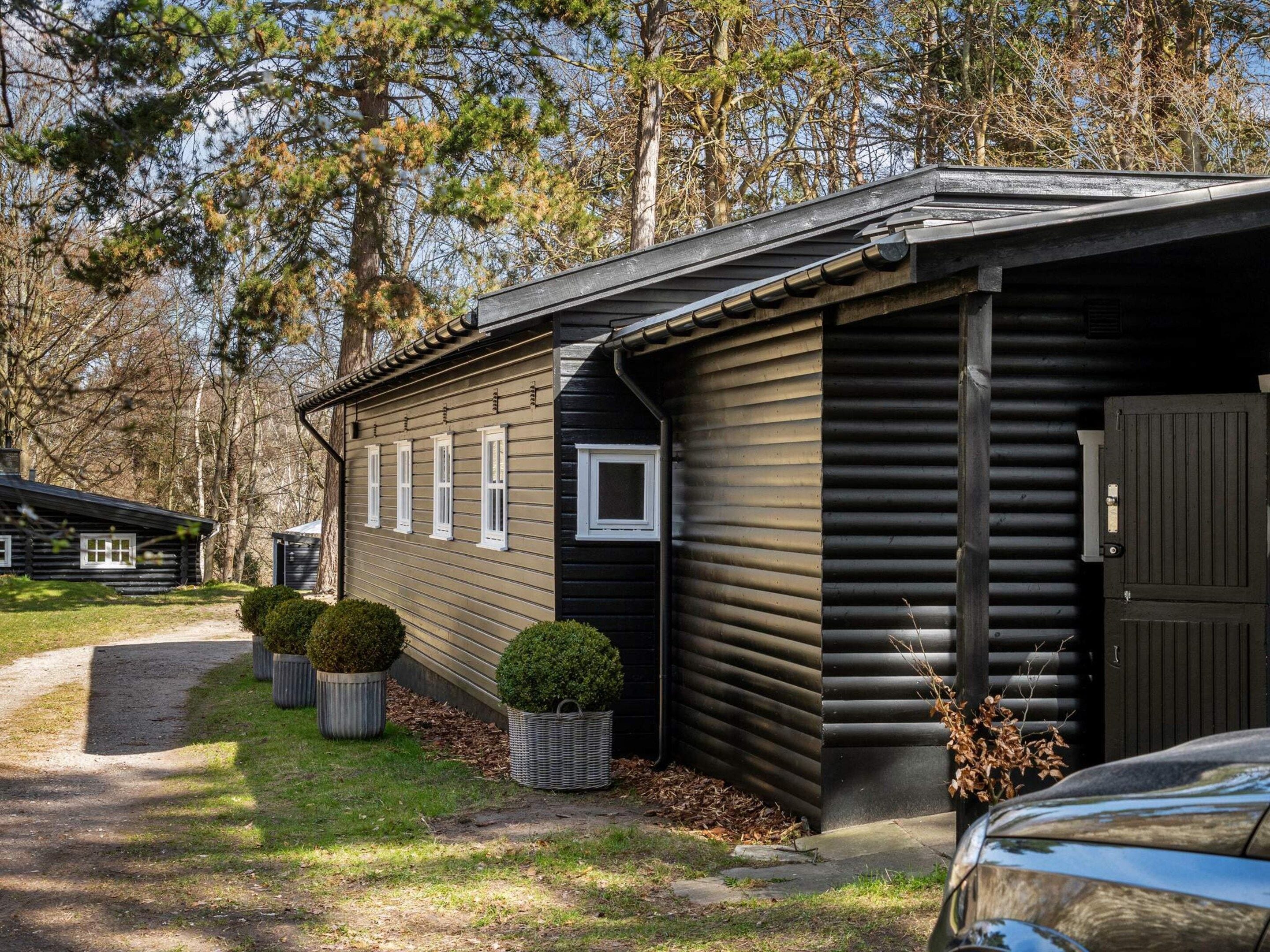 A cabin with a sloped roof, a front door, and a small window.