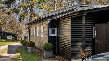 A cabin with a sloped roof, a front door, and a small window.