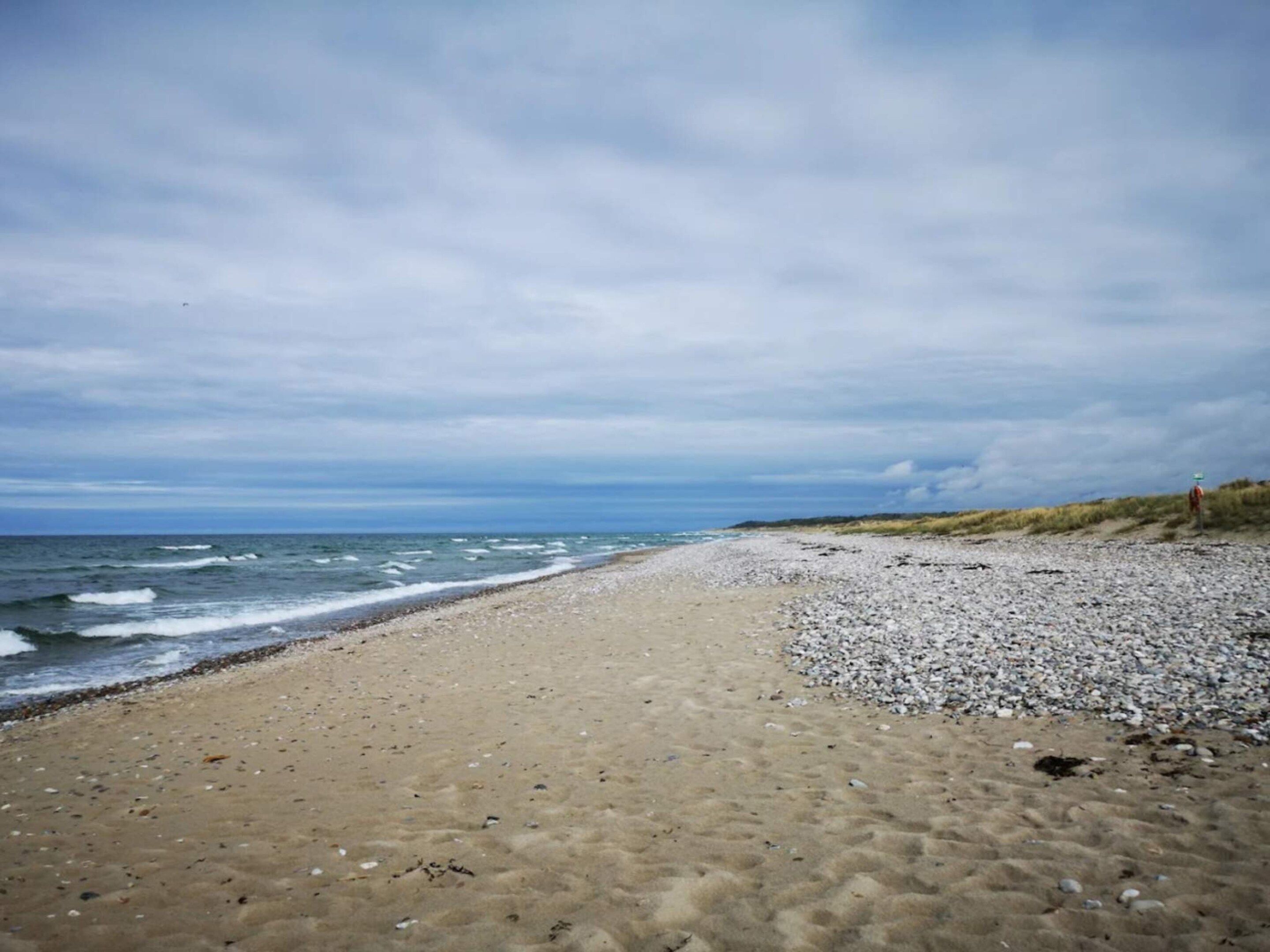 Une plage au rivage de galets et aux vagues déferlantes.
