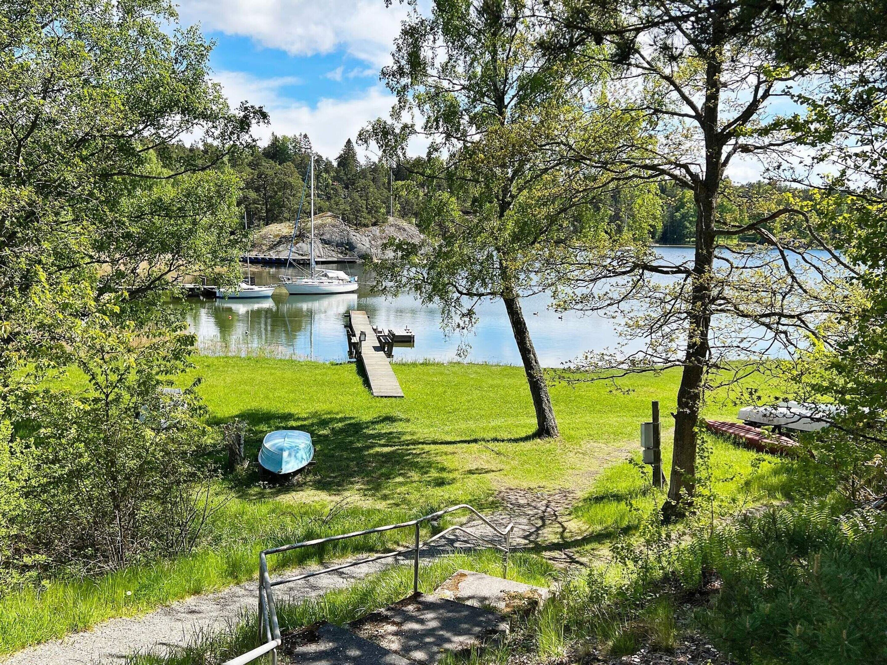 A lakeside park with a dock, grassy areas, and trees.