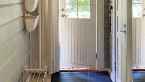 A hallway with a wooden bench, a window with a view of greenery, and a door with a white panel. - 4 Person Holiday Home in Hjarnarp (Hjarnarp)