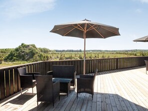 A wooden deck with outdoor furniture and a large umbrella.