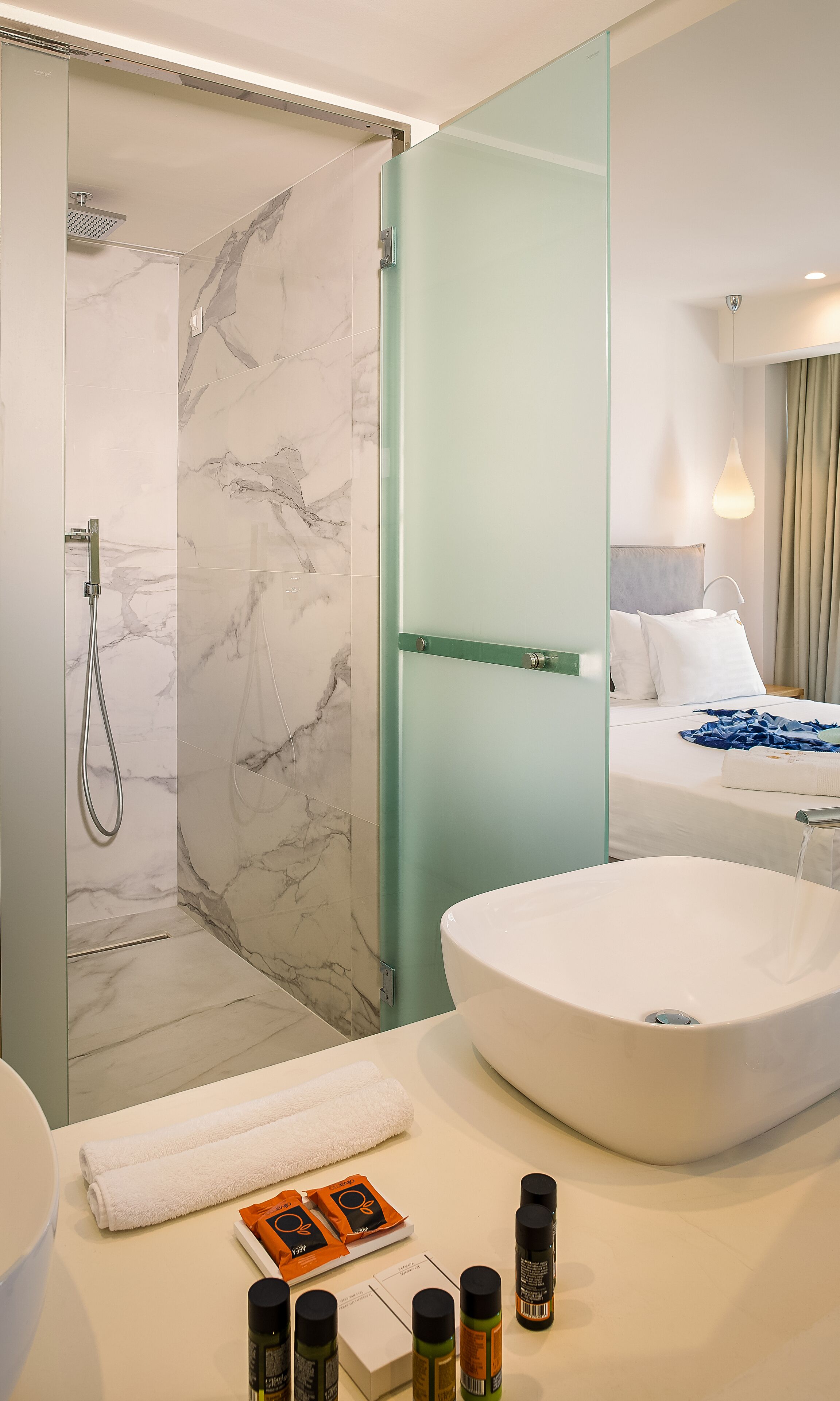 A modern bathroom with a walk-in shower, a large bathtub, and a vanity with toiletries.