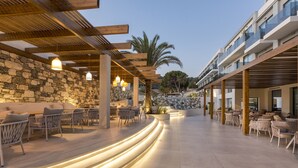 An outdoor seating area with modern furniture and a stone wall. - Samian Mare Hotel Suites & Spa (Samos)