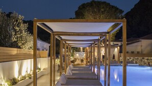 A pool area with a wooden pergola structure, a clear night sky, and a mountain backdrop. - Samian Mare Hotel Suites & Spa (Samos)