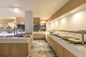 Een moderne keuken met een centraal eiland, houten kastjes en een geruit vloertje.