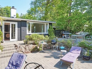 A patio with outdoor furniture, a grill, and a house with a chimney. - 6 Person Holiday Home in Vejby (Vejby)