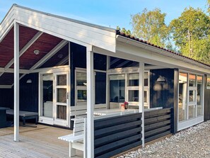 A covered outdoor area with a wooden deck, a bench, and a table. - 4 Person Holiday Home in Oksbol (Oksbol)