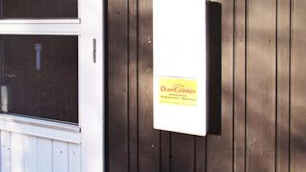 En dörr av trä med en skylt där det står ”Dan Center”.