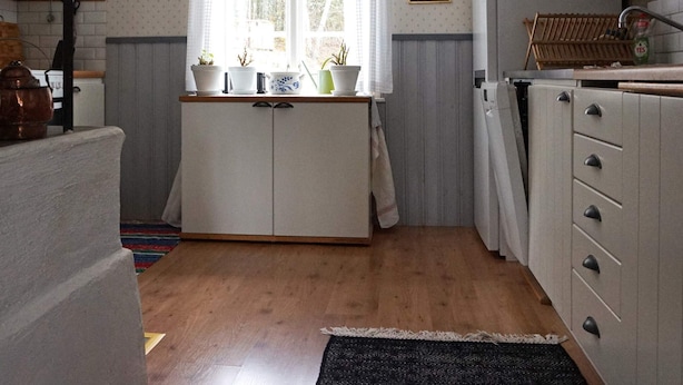 Keittiössä on ikkuna, kaappeja ja katosta roikkuva valaisin.