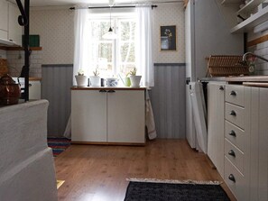 Eine Küche mit Fenster, Schränken und einer Pendelleuchte.