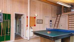 Et bordtennisbord i et rum med trævægge og en åben alkove.