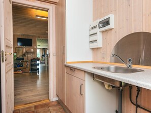 Una cocina con armarios de madera, un lavamanos de acero inoxidable y un horno empotrado.