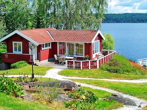 A red cabin with a deck, a window, and a door. - 2 Person Holiday Home in Ammeberg-by Traum (Åmmeberg)