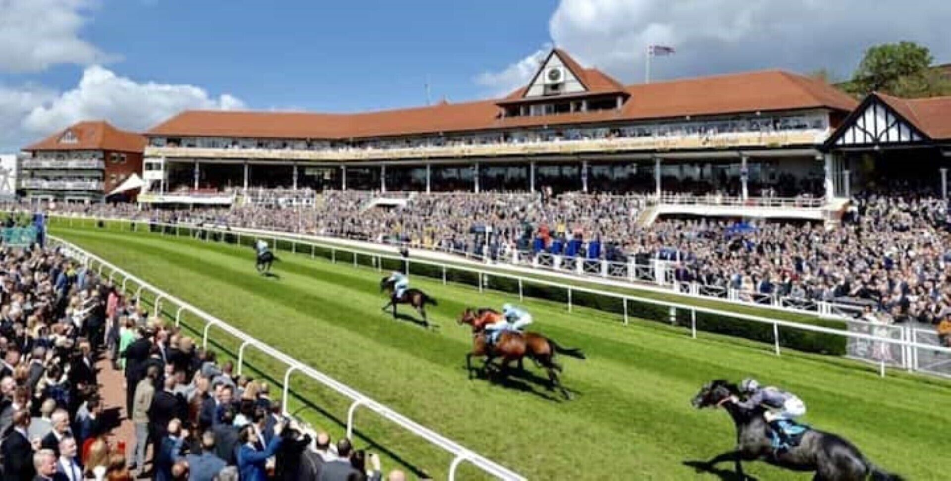 Un vaste stade intérieur doté de plusieurs niveaux de gradins, d’une piste centrale pour les courses de chevaux et accueillant une foule nombreuse de spectateurs.